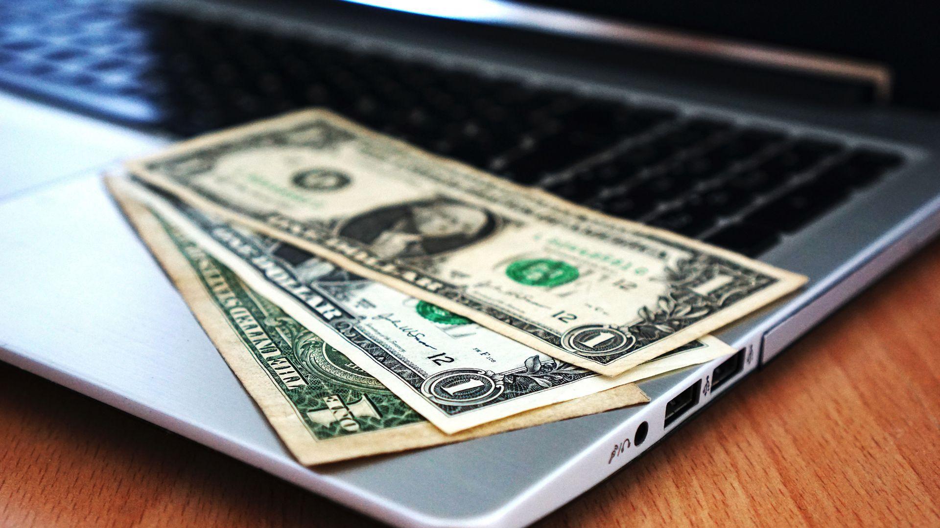 U.S. bank notes on a laptop