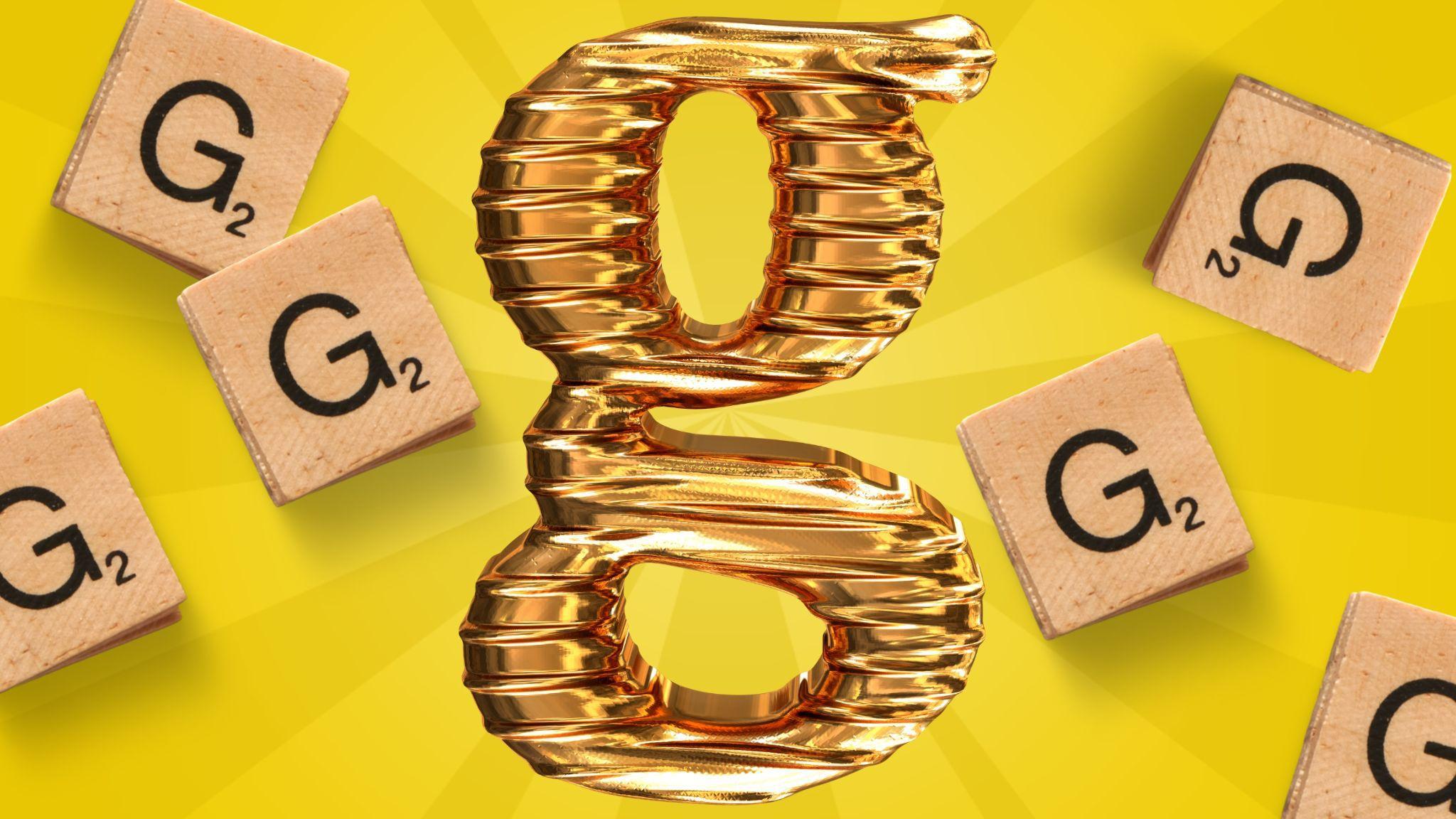 A golden foil “g” sits on top of a yellow background, surrounded by Scrabble pieces.