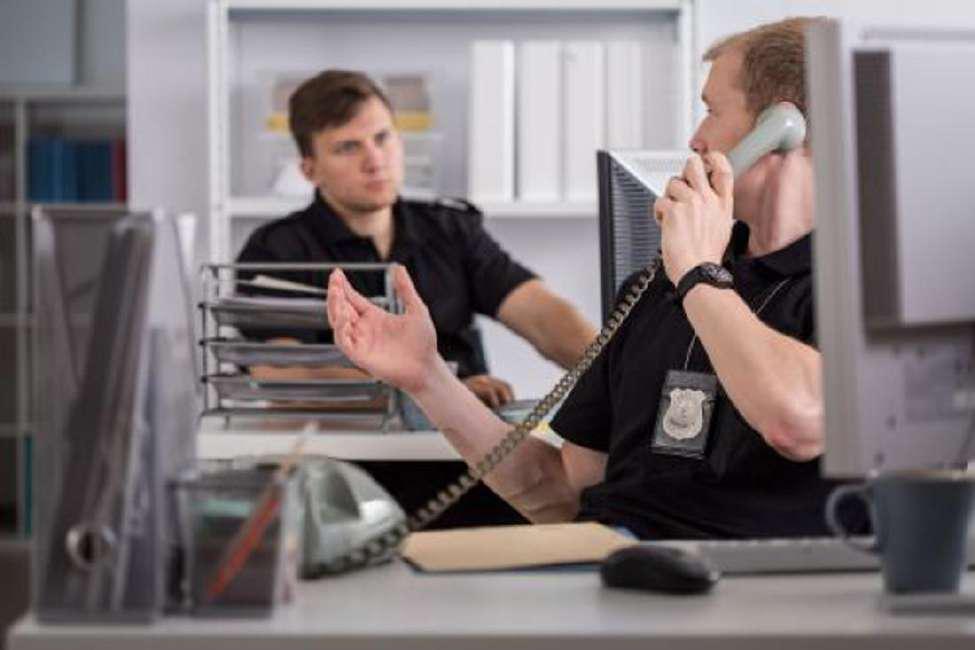 Police officer on the phone explaining the call to a fellow officer