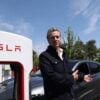 California Governor Gavin Newsom stands next to a Tesla charger with his own electric vehicle