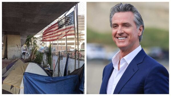 A homeless camp sits under a bridge in San Jose while Newsom smiles while looking at something off camera.
