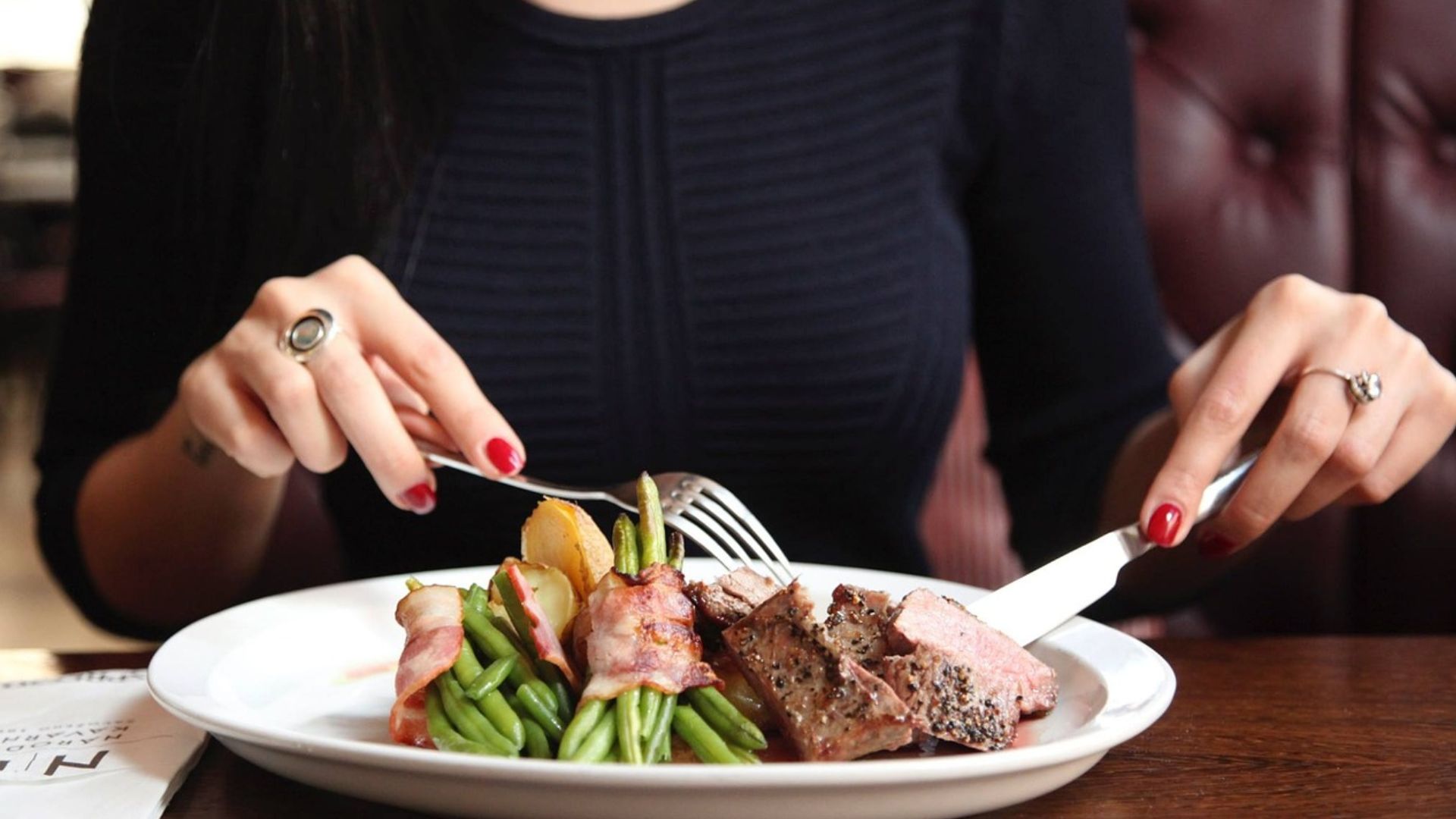 Woman Eating Steak Dinner at a Restaurant